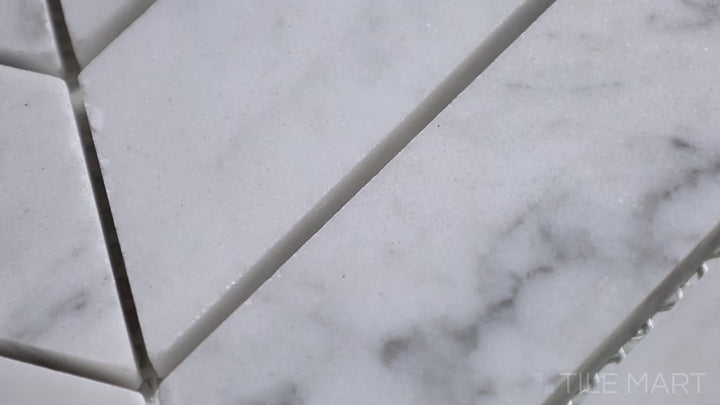 Video of Sto-Re Carrara Chevron Polished Marble Mosaic. A stunning Carrara marble mosaic with a chevron pattern, polished for a radiant effect.