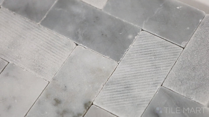 Video of Minute Mosaix Carrara White Herringbone Marble, Limestone Mosaic. A classic Carrara marble mosaic in a stylish herringbone pattern, perfect for elegant spaces.