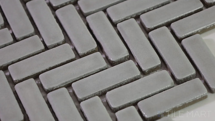 Video showcasing Foundations Pewter Herringbone Tilt Glossy Ceramic Mosaic. A refined ceramic mosaic with a glossy herringbone pattern, adding texture and depth to any space.