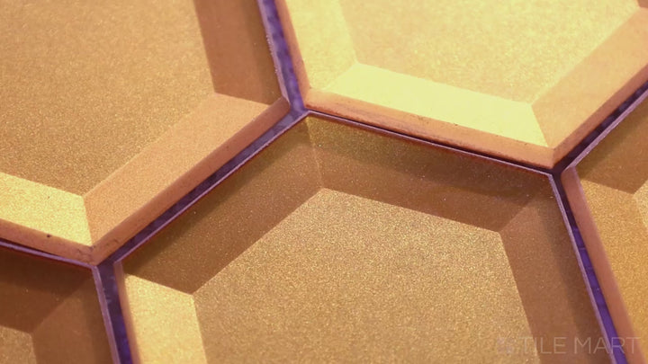 Video of Bold Glass Gold 3-inch Hexagon Glossy Mosaic. A radiant gold glass tile with a lustrous glossy finish, offering a luxurious and eye-catching design with a unique hexagonal layout.