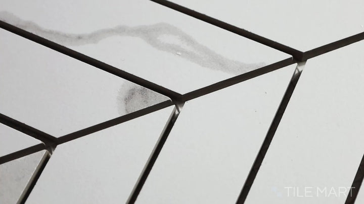 Video of Eden Statuary Chevron Matte Porcelain Mosaic. A luxurious white marble-look chevron tile with soft gray veining and a matte texture.
