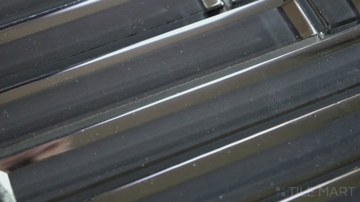 Video highlighting Modern Glass Dark Grey Herringbone Glossy Mosaic. A deep dark grey glass tile with a reflective surface, arranged in an elegant herringbone layout for a contemporary feel.