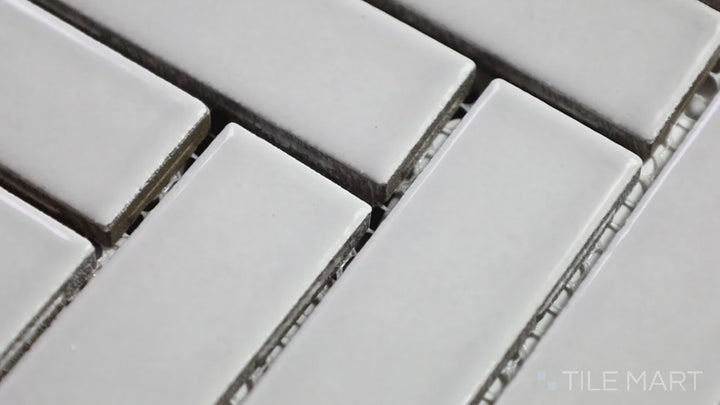 Video showcasing Domino Gray Herringbone Glossy Porcelain Mosaic. A modern herringbone tile in glossy gray for a refined and dynamic aesthetic.