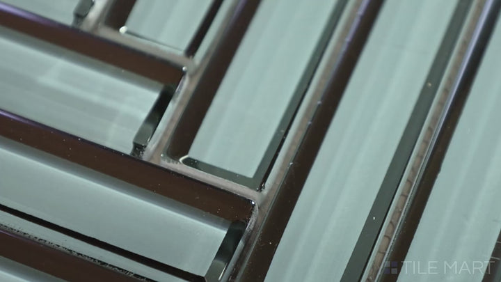 Video of Modern Glass Green Herringbone Glossy Mosaic. A rich green glass tile with a glossy sheen, showcasing a stylish herringbone design that enhances visual depth and vibrancy.